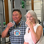 Chief Michael Starr and Minister Hajdu drinking from their glasses of water at the water treatment plant.