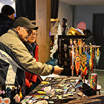 A visiting couple admiring handmade jewelry. 